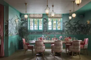 Casadonna South Private Dining Room with pink chairs, tropical wallpaper, and floral table decor.