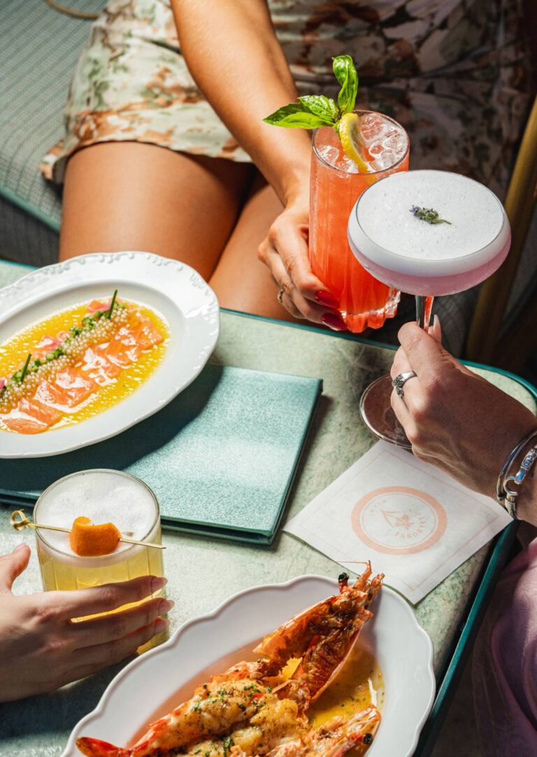 Casadonna Miami salmon crudo with colorful cocktails on a pastel table.