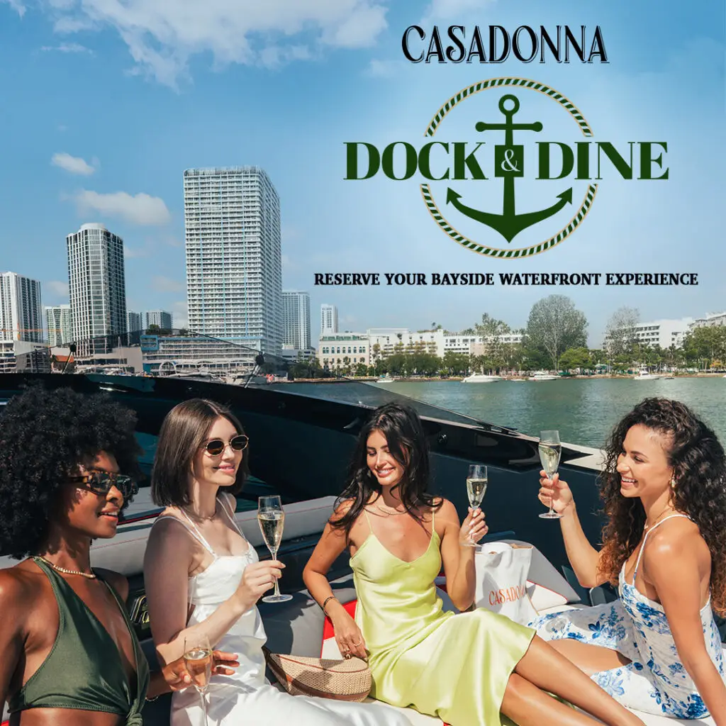 Group of women enjoying champagne on a yacht with a waterfront view of Miami, promoting the Dock & Dine experience at Casadonna Miami